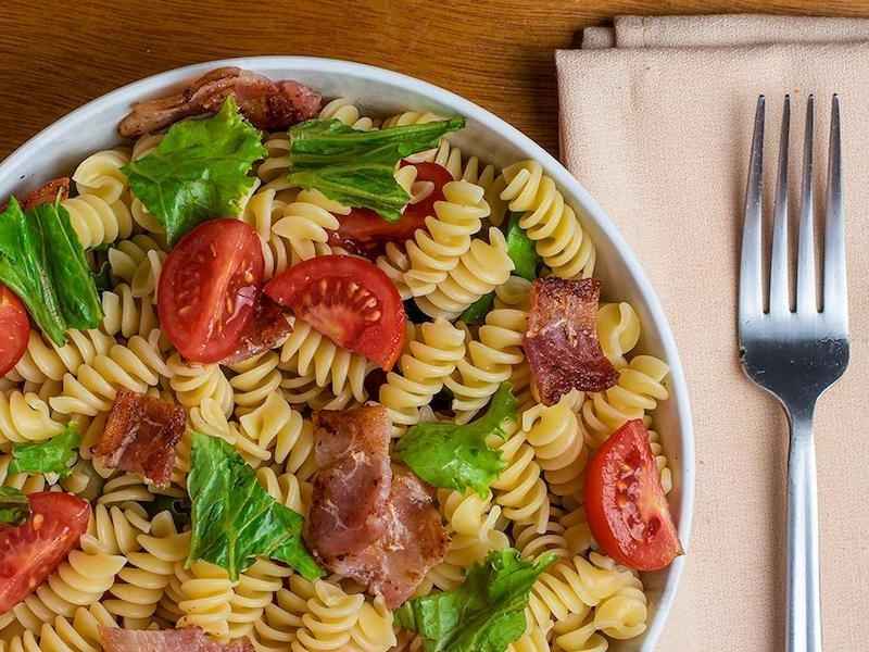 bowl of BLT pasta salad sitting on a table